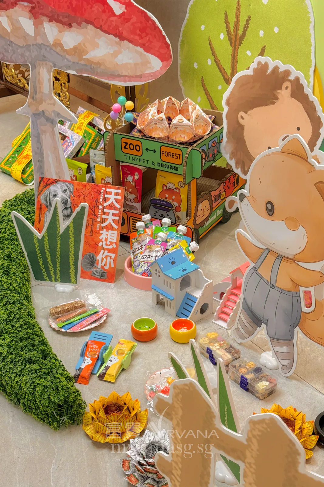 Pet offerings at the Rainbow Bridge corner: treats, small ceramic bowls, folded joss-paper lotuses and a dog-shaped sign reading 天天想你, I miss you every day