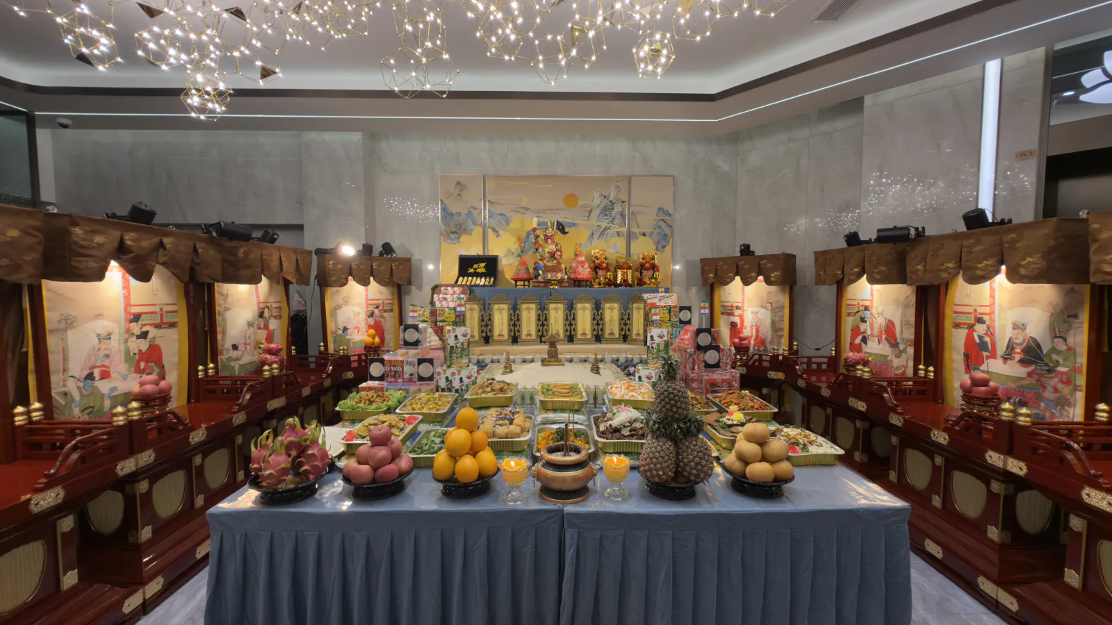 Offering table at the Seventh Month prayer services at Nirvana Memorial Garden, laden with fruit and packaged food before the image of Mian Ran Da Shi, flanked by the paper houses Tong Gui Suo and Han Lin Yuan